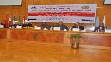 مؤتمر دولي في جامعة الأزهر، يضم مجموعة من المتحدثين من خلفيات متنوعة، يناقش قضايا التراث الثقافي وعلاج التطرف. يوضح المنصة لافتات تحمل أسماء الدول المشاركة، مع وجود أعلام متعددة.