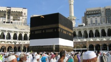 مكة المكرمة، الكعبة المشرفة محاطة بالحجاج أثناء أداء مناسك العمرة، تظهر المباني الحديثة حول الحرم.