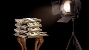 كوميديا توضح كومة من النقود موضوعة على طاولة خشبية، مضاءة بواسطة ضوء كشاف، مما يبرز أهمية المال والنجاح.