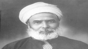 صورة تبرز شخصية رجل مسن ذو لحية بيضاء وشعر رمادي تحت عمامة بيضاء. يرتدي جلباباً داكناً، ويظهر تعبيره الجاد في خلفية ضبابية. تعكس الصورة الأناقة والتقليد الثقافي.