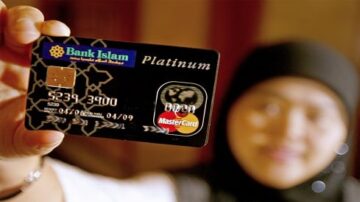 بطاقة ائتمانية بلاتينية من بنك إسلام تحمل شعار ماستركارد، تُظهر يد امرأة ترتدي حجابًا، مع خلفية غير واضحة.