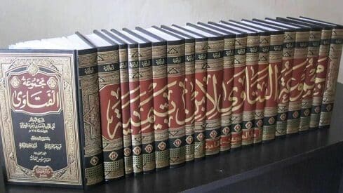 كتب عربية منسقة على رف، بأغلفة مزخرفة ونقوش ذهبية.