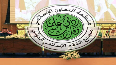 شعار منظمة التعاون الإسلامي يبرز في اجتماع مع أشخاص وزهور وأعلام.