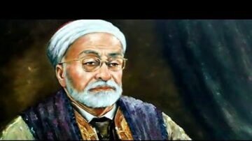 صورة لرجل مسن ذو لحية بيضاء وشعر رمادي، يرتدي نظارات وقبعة تقليدية. يظهر في الخلفية لون داكن، مما يبرز ملامح وجهه بتفاصيل دقيقة.