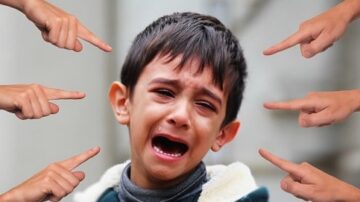 صبي صغير يبكي بشدة وسط مجموعة من الأيدي التي تشير إليه، مما يعكس شعورًا باللوم أو الانتقاد. تعبير وجهه يظهر الحزن والقلق، مما يبرز تأثير الضغوط الاجتماعية.