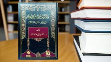 كتاب يحمل عنوان "علم الحلال والحرام" للمؤلف د. صلاح الدين ابن عياد. يظهر الكتاب في مقدمة الصورة مع خلفية لمكتبة تحتوي على كتب أخرى. التصميم مميز بغطاء جلدي مزخرف باللون الأزرق والذهبي.