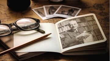 صورة تحتوي على دفتر ملاحظات مفتوح يظهر صورة بالأبيض والأسود لرجل يحمل كتابًا، مع نظارات وقلم رصاص موضوعة بجانب الدفتر. خلفية الصورة تتضمن خريطة قديمة وبعض الصور الفوتوغرافية.