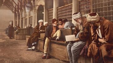 مجموعة من الرجال يجلسون في مكان عام، يرتدون ملابس تقليدية، ويقرأون أو يتناقشون. تظهر خلفية تاريخية مع تفاصيل معمارية قديمة. الألوان دافئة وتضفي جوًا من الحنين للماضي.