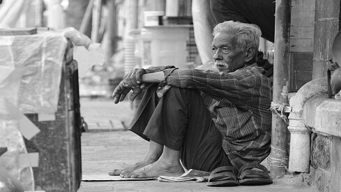 رجل مسن يجلس في الشارع