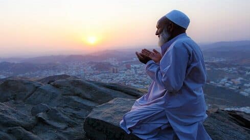مسلم يدعو ربه فوق جبل وقت غروب الشمس