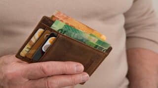 رجل يمسك محفظة بها نقود ورقية