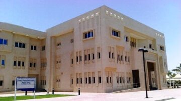 مبنى حديث بتصميم معماري فاخر، يظهر واجهته المصنوعة من الحجر الفاتح والنوافذ المستطيلة. يتواجد في محيطه مساحات خضراء وموقف سيارات. المبنى يرمز إلى التطور الحضاري ويشكل جزءًا من مركز ثقافي أو تعليمي.