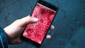 هاتف محمول في يد شخص يظهر خلفية تتضمن خلايا فيروسية حمراء، مما يعكس موضوع الصحة والفيروسات.