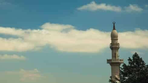 مأذة مسجد في السماء شامخة مع ظهور واضح للسحاب