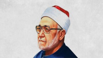 صورة لرجل مسن يرتدي نظارات وقبعة تقليدية، مع لحية رمادية. يظهر في خلفية فاتحة. تعكس الصورة هيبة الشخصية وتاريخها الثقافي.