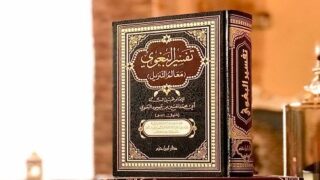 كتاب "تفسير الطبري" على سطح بغلاف مزخرف بألوان داكنة وتفاصيل ذهبية.