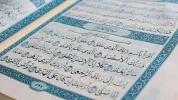 صفحة من المصحف الشريف تحتوي على آيات قرآنية مكتوبة بخط عربي جميل، مع تزيين ملون حول النص.