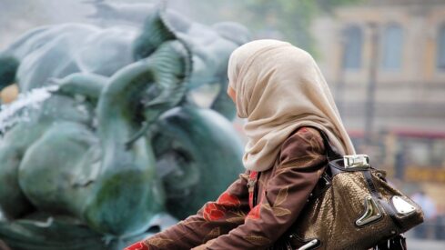 فتاة مسلمة ترتدي الحجاب وتستمع بالطبيعة