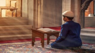 طفل يجلس في المسجد ويقرأ القرأن