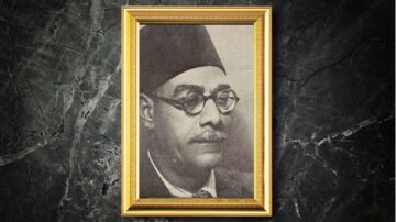 صورة تاريخية لرجل يرتدي نظارات وقبعة، يظهر بإطار ذهبي. تعكس الصورة طابعًا كلاسيكيًا وتاريخيًا.