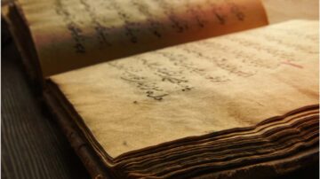 كتاب قديم مفتوح تظهر فيه صفحات صفراء مع نص مكتوب بخط عربي. الكتاب ذو غلاف جلدي وتحمل الصفحات علامات الزمن.