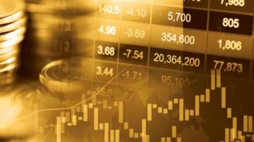صورة توضح مخططات سوق الأسهم مع عملات معدنية في الخلفية. تعرض البيانات المالية والأسعار بالألوان الذهبية، مما يعكس حركة السوق وتغيرات الأسعار.
