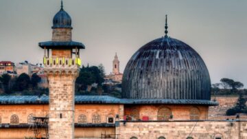 صورة تظهر قبة المسجد الأقصى بمآذنها الجميلة، مع خلفية تضم معالم تاريخية، تعكس العمارة الإسلامية في القدس.