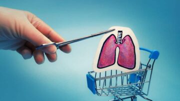 يد تظهر مقصًا يقص نموذجًا ملونًا للرئتين داخل عربة تسوق صغيرة، على خلفية زرقاء. يرمز المشهد إلى أهمية الصحة التنفسية وفكرة التسوق لمنتجات صحية.
