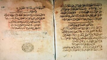 صفحتان من مخطوطة قديمة باللغة العربية، تحتوي على نصوص تاريخية مكتوبة بخط عربي جميل. الصفحة اليسرى تتضمن نصوصاً بخط واضح مع تعليقات باللون الأحمر، بينما الصفحة اليمنى تظهر نصوصاً إضافية وملاحظات. التصميم الفني والزخارف تبرز جمال الكتابة العربية التقليدية.