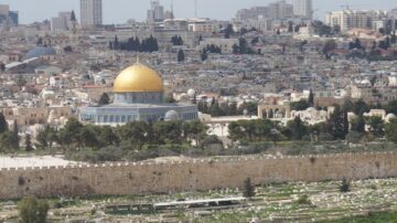 صورة لمدينة القدس مع قبة الصخرة الذهبية في المقدمة. تظهر المدينة القديمة والمباني المحيطة بها، مع مقبرة في الأسفل. السماء زرقاء والخلفية تحتوي على مبانٍ حديثة.