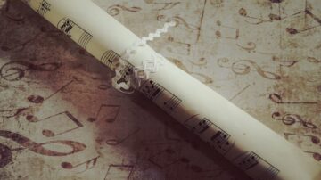 لفافة ورقية مزينة بالنوتات الموسيقية، موضوعة على خلفية تحمل رسومات لعلامات موسيقية.