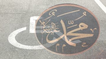 خط عربي يكتب اسم محمد، مع رمز للدخول المخصص لذوي الاحتياجات الخاصة على سطح الطريق.