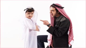 شخص بزي عربي يوجه اللوم الى طفل صغير برتدي زي عربي خليجي