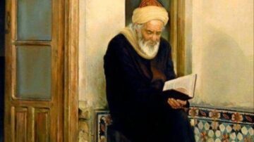 رجل مسن يجلس في زاوية غرفة تقليدية، يرتدي عمامة وقماشاً طويلاً، يقرأ كتاباً بتركيز. الجدران مزينة بأعمال فنية تقليدية، مما يضيف جوًا ثقافيًا.