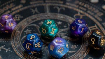 نردات ملونة بتصميم نجمي، تحتوي على رموز فلكية، موضوعة على خلفية دائرية مزخرفة بأرقام وأشكال نجوم. تعكس الصورة موضوع الفلك والأبراج، مما يجذب عشاق التنجيم والألعاب.