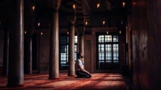 شاب يجلس في المسجد ويدعو الله