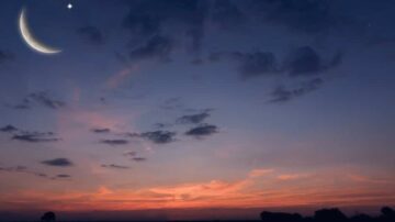 سماء غامقة مع هلال رقيق وكوكب مضيء يتلألأ في الأفق، تظهر سحب خفيفة مع ألوان غروب الشمس الدافئة، تعكس جمال الطبيعة في لحظة هادئة.