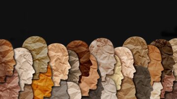 تكوين فني يظهر مجموعة من الوجوه البشرية بألوان بشرية متنوعة، مصنوعة من ورق مكرمش، على خلفية داكنة. التصميم يركز على تنوع البشرة ويعكس الهوية الإنسانية.