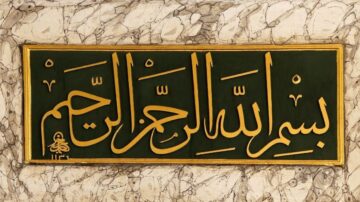 نص عربي مزخرف بالذهب على خلفية خضراء، يتضمن عبارة "بسم الله الرحمن الرحيم" بأسلوب فن الخط العربي، مع تفاصيل دقيقة على الحواف.