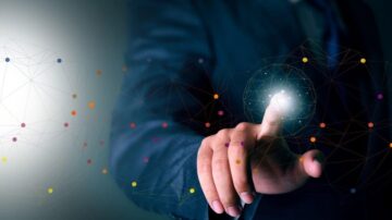 رجل يرتدي بدلة يمد إصبعه نحو نقطة مضيئة في وسط شبكة من النقاط الملونة، مما يرمز إلى التكنولوجيا والتواصل.