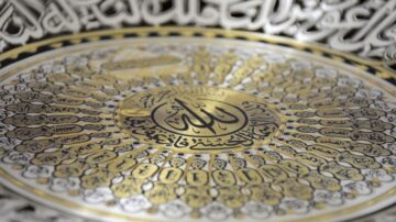 تصميم فني مُعقد يبرز الخط العربي بألوان الذهب والفضة، يحمل عبارة "الله" في المركز مع أنماط زخرفية تُحيط به، مما يُظهر جمال الفنون الإسلامية.