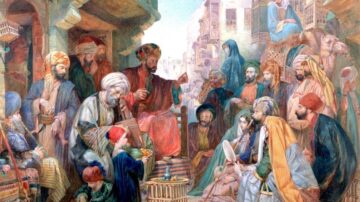 مجموعة من الرجال والنساء في سوق شعبي، يجلسون حول شخصية محورية تتحدث. يرتدون ملابس تقليدية ملونة، وتظهر تفاصيل تاريخية للبيئة المحيطة، مثل المباني القديمة والسلع المعروضة. تعكس الصورة الحياة الثقافية والاجتماعية في زمن قديم.