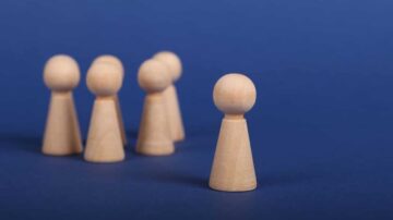 ستة مكعبات خشبية صغيرة بألوان طبيعية، تتواجد في مجموعة مع وجود واحد منها في المقدمة، على خلفية زرقاء. تعكس الصورة مفهوم التعاون أو العمل الجماعي.