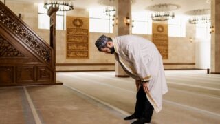 A man observing prayer inside the Masjid