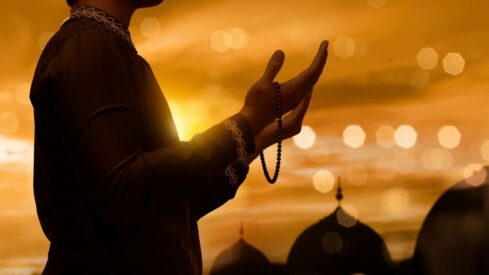 Muslim man raising hand and praying
