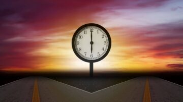 ساعة كبيرة على قاعدة وسط منظر غروب الشمس، تظهر في خلفية السماء الملونة. الطريق ينقسم إلى اتجاهين، مما يرمز إلى خيارات الحياة والقرارات.