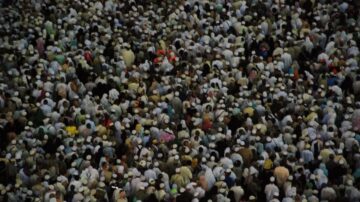 حشد كبير من الناس يرتدون القبعات البيضاء، يظهر في صورة من الأعلى. يعبّر المشهد عن تجمع جماهيري، محتمل أن يكون في مناسبة دينية أو احتفال.