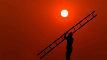 رجل يحمل سلمًا في وضعية ظلية أمام شمس غاربة في سماء برتقالية. الصورة تعبر عن العمل الشاق والتحدي، مع التركيز على الجمال الطبيعي للغروب.