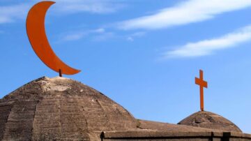 صورة توضح قبتين لمبنى ديني، واحدة تحمل هلالًا برتقاليًا والأخرى صليبًا برتقاليًا، مع سماء زرقاء وص Clouds بيضاء في الخلفية، تعكس التنوع الديني والتاريخ الثقافي.