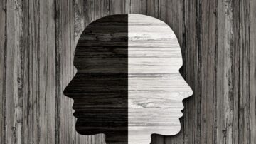 صورة توضح ظلال وجهين متقابلين بتباين بين اللونين الأسود والأبيض، مع خلفية من الخشب بلون طبيعي. تعبر عن التناقضات والتواصل بين الشخصيات.